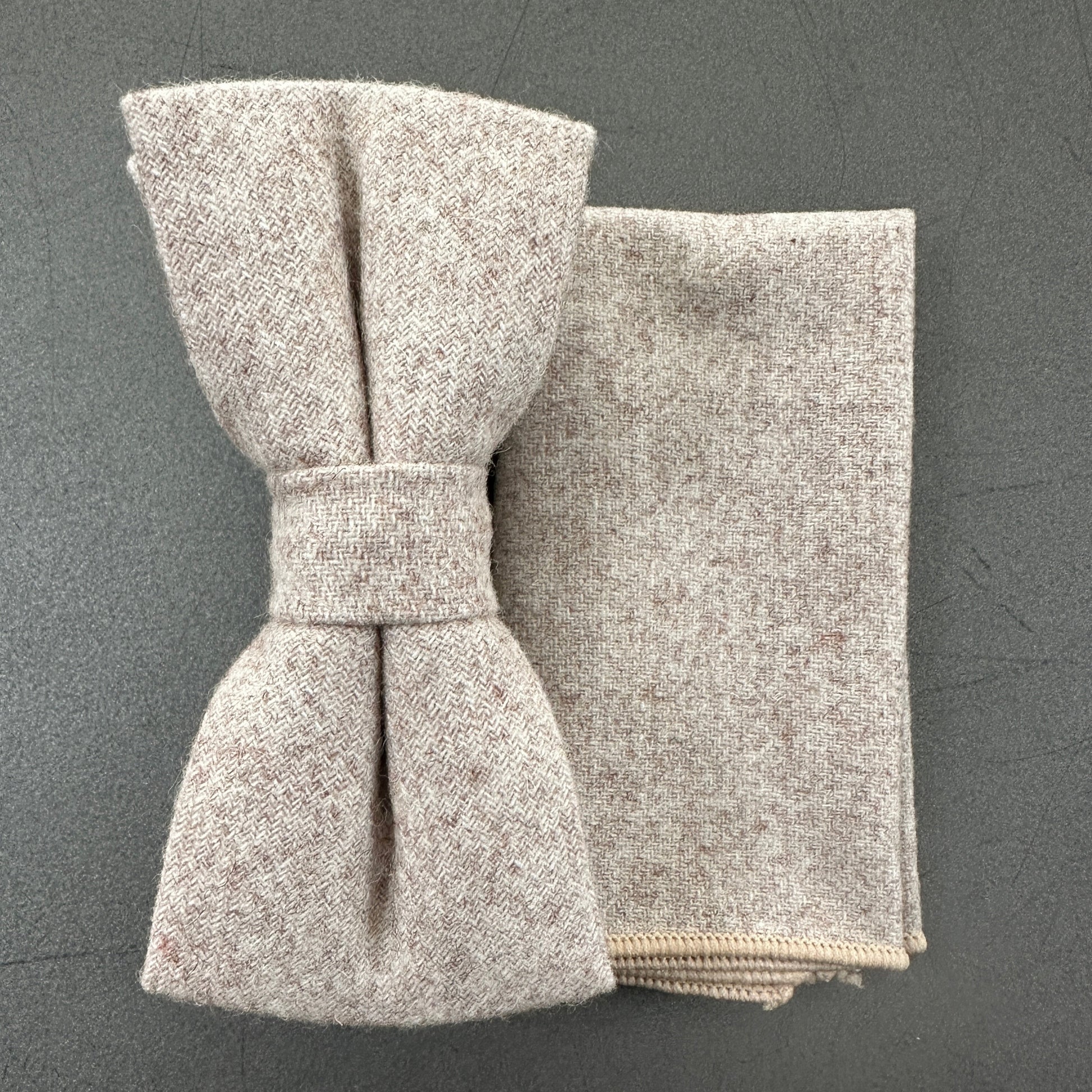 A cream wool bow tie and matching pocket square set for men.