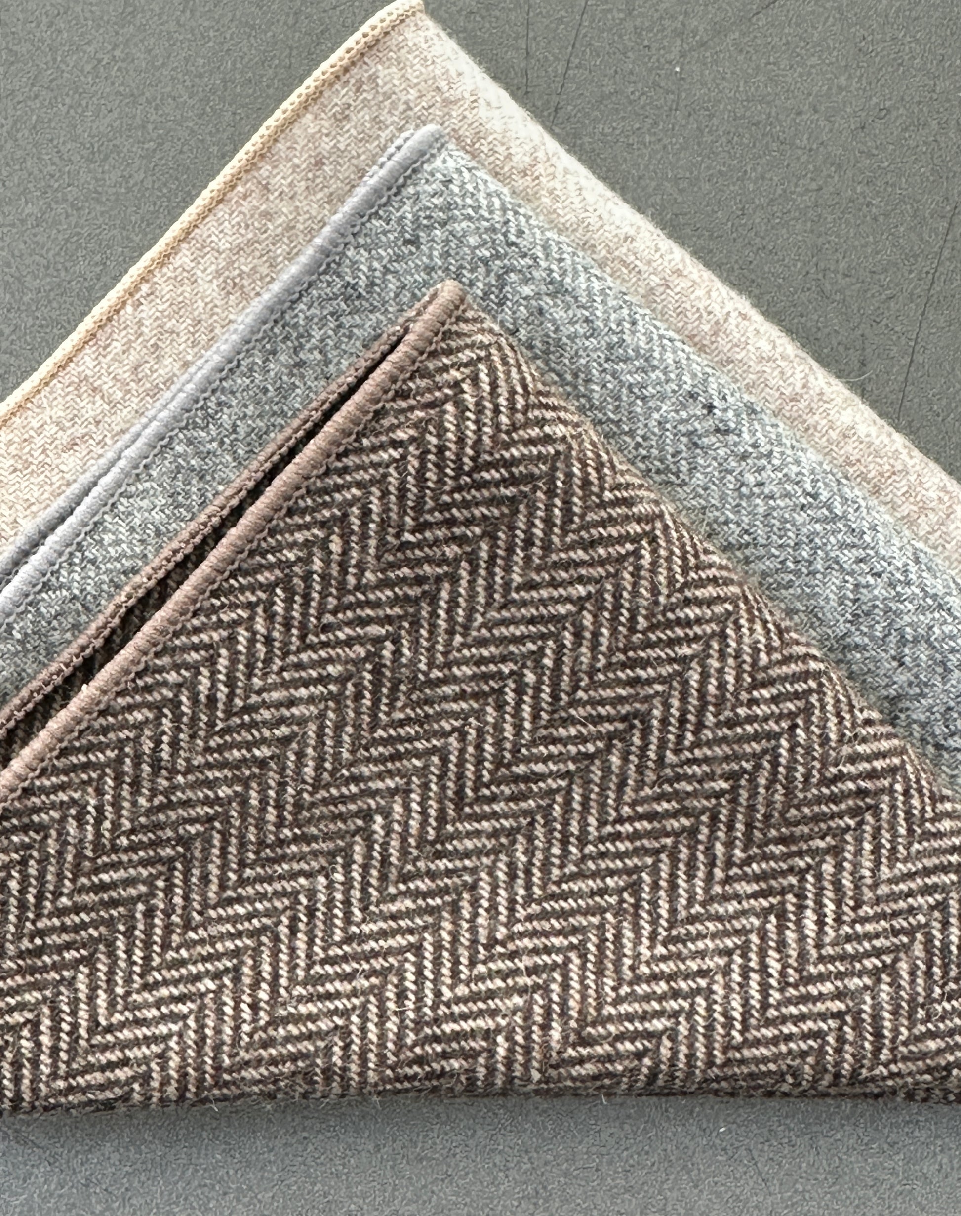 This is a set of three wool pocket squares in a herringbone design in grey, cream and brown. Ideal for mens gifts. Perfect EDC hanks for every day carry.