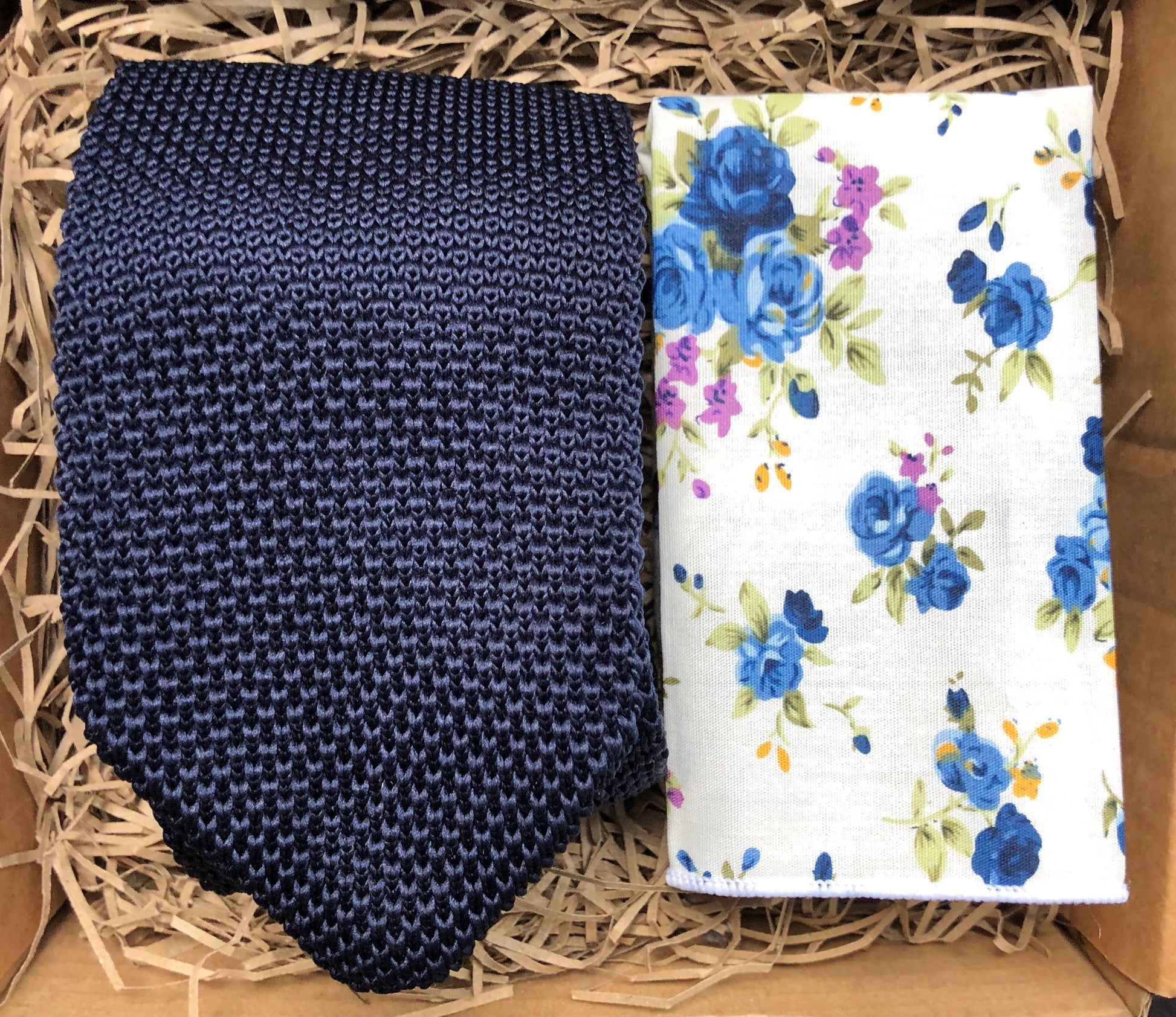 A man's tie in a navy knitted fabric and a white cotton pocket square handkerchief. The set is ideal as a men's gift and comes gift wrapped by Daisy and Oak Studio.