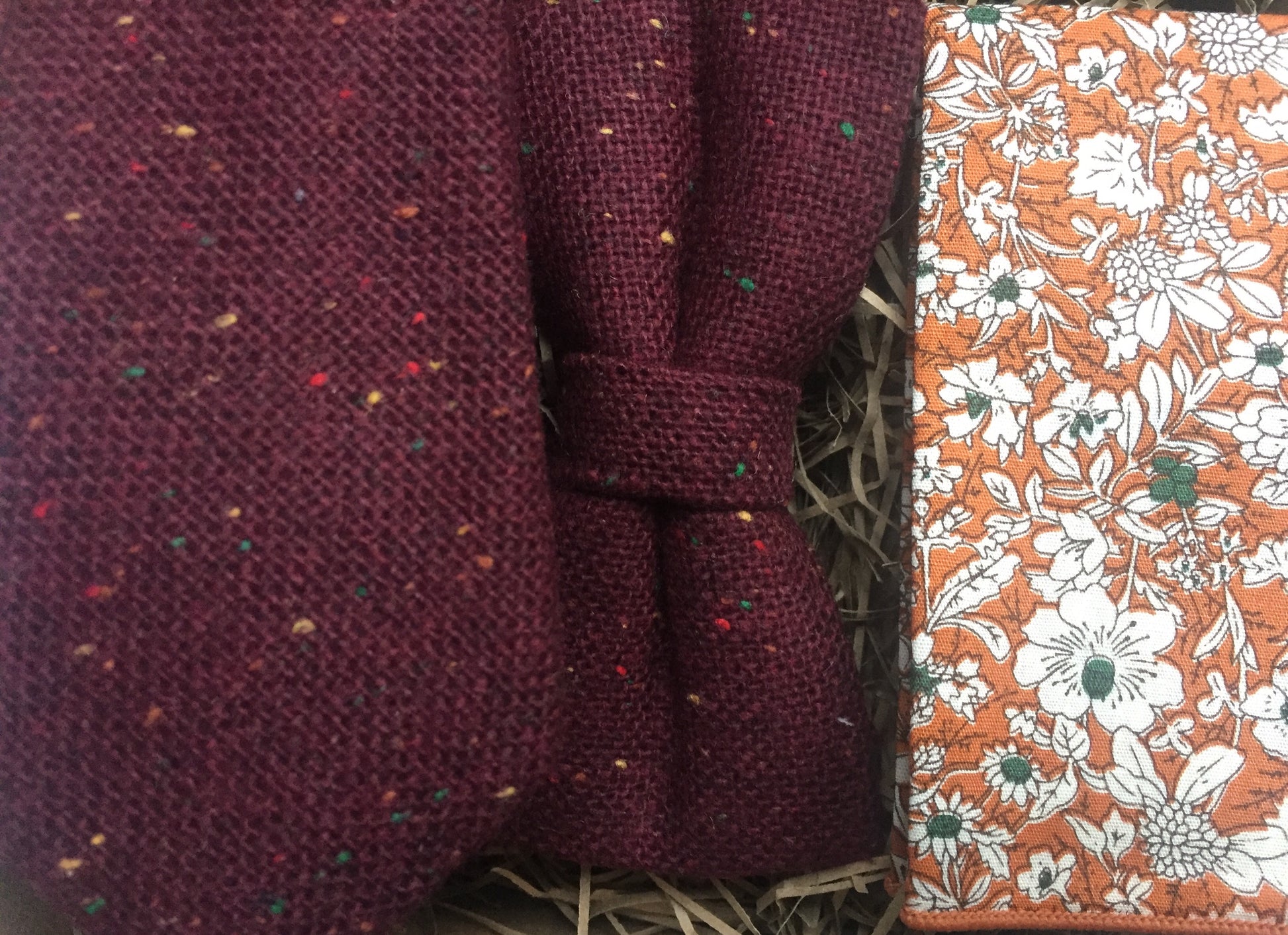 A photo of a men's flecked wool tie, bow tie and pocket square. The fabric is wool and has a red, yellow and green fleck. The ties are handmade by Daisy and Oak Studio and come with beautiful free gift wrapping.